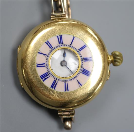 An 18ct gold and enamel half hunter manual wind wrist watch by Smith & Son, London, on a 9ct gold bracelet.